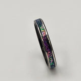Hand-turned dichroic resin ring on a stainless steel band, shifting purple, blue, and green in the light.
