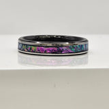 Hand-turned dichroic resin ring on a stainless steel band, shifting purple, blue, and green in the light.