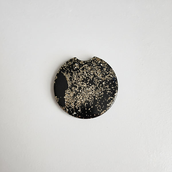 A black and gold glitter car coaster 