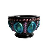 A black resin trinket bowl with blue and pink accents on the rim.