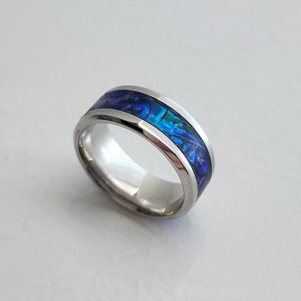 Hand-turned dichroic resin ring on a 4mm stainless steel band shifting blue and green in the light