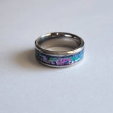 Hand-turned dichroic resin ring on a stainless steel band, shifting purple, blue, and green in the light.