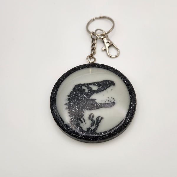 Black and white resin dinosaur bones keychain with Tyrannosaurus design.