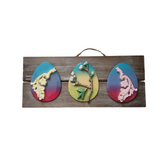 A decorative Easter egg sign featuring three different colored eggs on a wooden board with a hanger at the top.