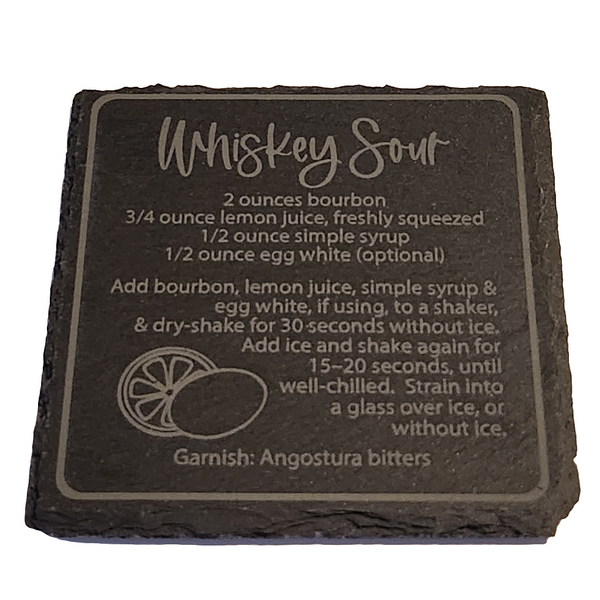 A black slate coaster with engraved text detailing a Whiskey Sour recipe, 