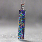Fire burl dichroic pendant with iridescent Dichrolam resin on stainless steel chain.