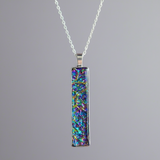 Fire burl dichroic pendant with iridescent Dichrolam resin on stainless steel chain.