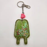 Double popsicle shaker keychain filled with oil and floating charms.
