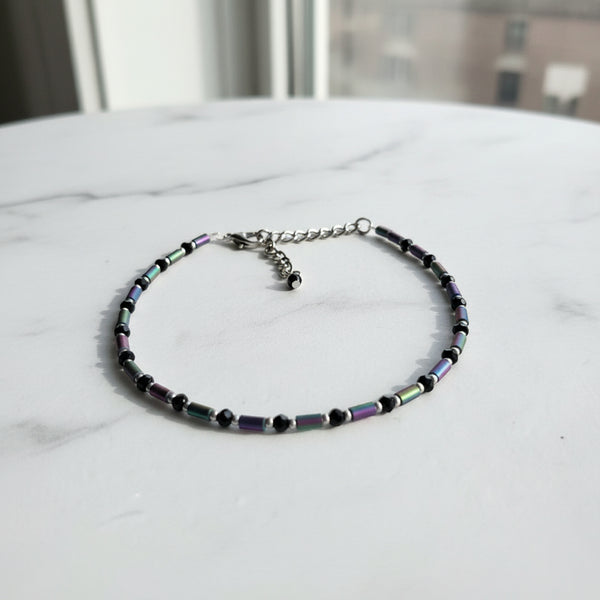 An adjustable ankle bracelet with multicolored beads and a chain.