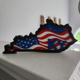 A decorative plaque in the shape of Kentucky with the American flag colors and the letter 'KY' on it, made of wood and resin