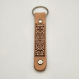 Laser-engraved leather key fob keychain with detailed design.