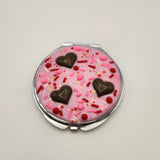 Dessert-inspired resin compact mirror with heart details and faux pink frosting design