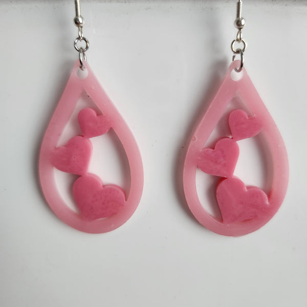 A pair of pink teardrop heart earrings with stainless steel hooks.