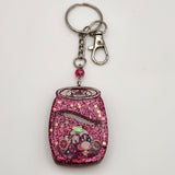 Pop can shaker keychain filled with oil and floating charms