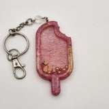 Popsicle shaker keychain filled with oil and moving charms.