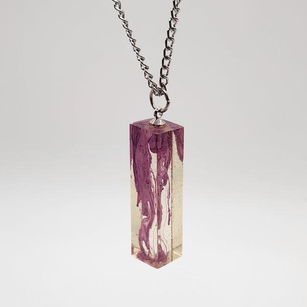 Suspended ink resin pendant on silver stainless steel chain.