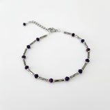 Adjustable silver ankle bracelet with a chain and purple  beads.