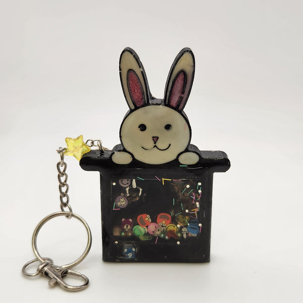 Rabbit in a hat shaker keychain filled with oil and moving charms.