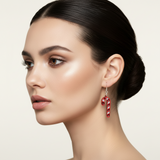Woman wearing a red earring on a neutral background