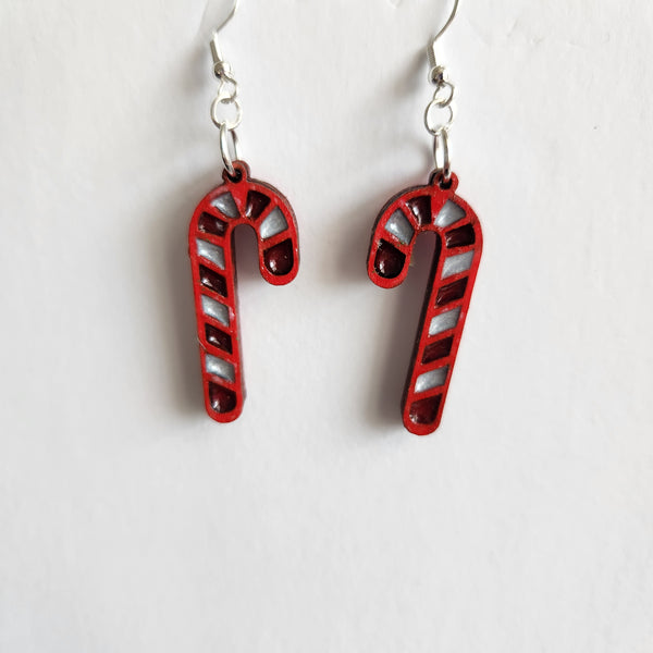 A pair of red and white striped candy cane earrings with silver hooks.