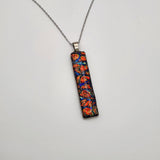 Red burl dichroic pendant with iridescent Dichrolam resin on stainless steel chain