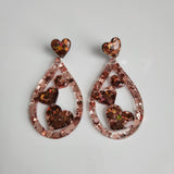 Teardrop resin earrings with heart accents in multiple colors by Blue Bourbon Designs