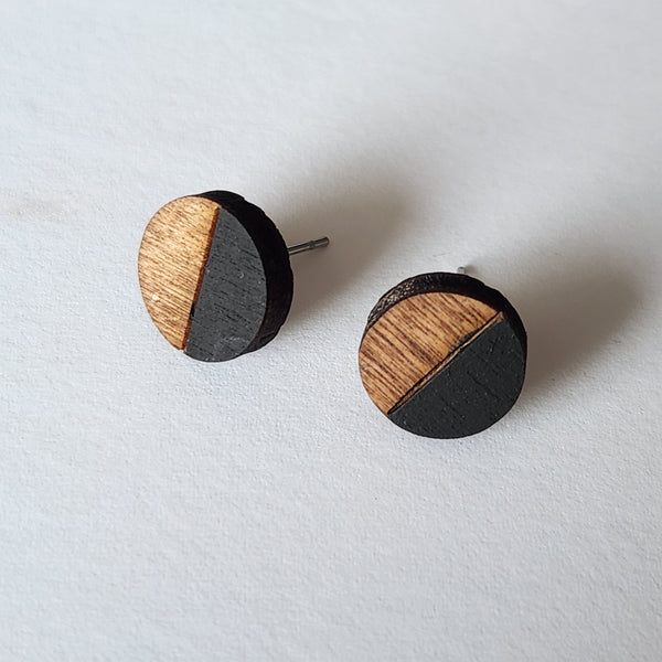 A pair of round black and wood stud earrings 