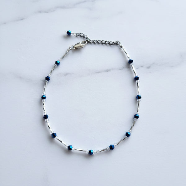Adjustable blue and white beaded anklet with a silver tube beans and adjustable chain.