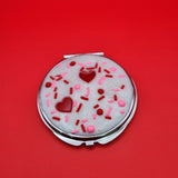 Dessert-inspired resin compact mirror with heart details and faux white frosting design