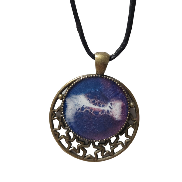 Round metal crescent moon and star pendant with resin center on a leather cord.