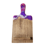 A wooden charcuterie cell phone holder with a marbled purple and brown finish.