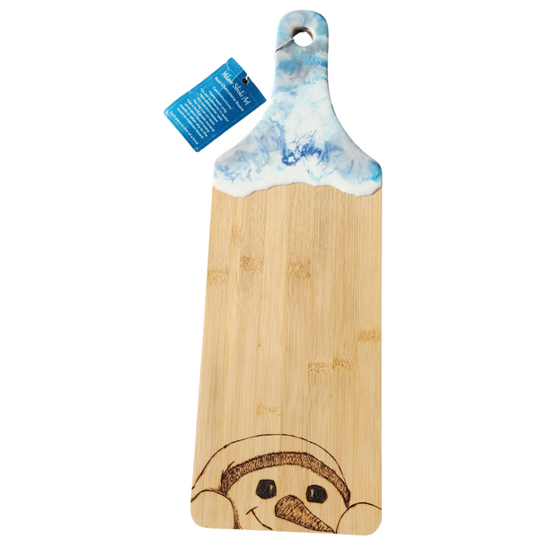 A tall bamboo charcuterie board with a handle, featuring a hand-drawn image of a snowman on the surface.