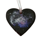 A black resin heart-shaped ornament with a space-themed design, featuring stars and a purple hue.